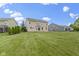 Spacious backyard with a lush green lawn, a patio and stone fireplace at 543 Amersham Ct, Avon, IN 46123