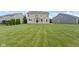 Large backyard with lush green lawn, mature trees and patio with stone fireplace at 543 Amersham Ct, Avon, IN 46123