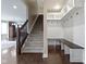 Entryway with custom storage bench, staircase, and hardwood flooring at 543 Amersham Ct, Avon, IN 46123