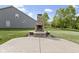 A stone outdoor fireplace adds charm and warmth to the concrete patio and spacious backyard at 543 Amersham Ct, Avon, IN 46123