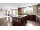 Open kitchen with dark wood cabinets, granite counters, hardwood floors, and stainless appliances at 543 Amersham Ct, Avon, IN 46123