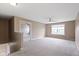 Neutral-toned upstairs living room with plush carpeting, a ceiling fan, and a sunlit window at 543 Amersham Ct, Avon, IN 46123