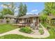 Charming brick home with a spacious deck and outdoor seating, surrounded by a well-manicured lawn and lush landscaping at 5616 Winthrop Ave, Indianapolis, IN 46220
