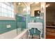 Bathroom featuring blue tiling, a glass enclosed shower/tub combination, and an ornate sink and vanity at 5616 Winthrop Ave, Indianapolis, IN 46220