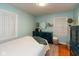 Well-lit bedroom features light blue walls, hardwood floors, dresser, and two bright windows with curtains at 5616 Winthrop Ave, Indianapolis, IN 46220
