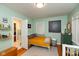 Bright bedroom with mint green walls and hardwood floors features built-in shelves and decorative decor at 5616 Winthrop Ave, Indianapolis, IN 46220