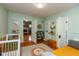 Spacious bedroom featuring mint green walls, hardwood floors and multiple doorways to other rooms at 5616 Winthrop Ave, Indianapolis, IN 46220