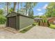 Single car detached garage with ample parking space, situated on a lot with mature trees and a partial view of the house at 5616 Winthrop Ave, Indianapolis, IN 46220