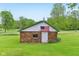 Brick outbuilding with an American flag, a white door, and green trim at 6012 S 625 W, Pendleton, IN 46064