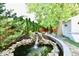 Beautiful backyard with a tiered rock waterfall flowing into a koi pond, surrounded by lush greenery and brick pathway at 6187 Crittenden Ave, Indianapolis, IN 46220