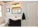 Bright bathroom featuring wainscoting, updated vanity, and a decorative light fixture at 6187 Crittenden Ave, Indianapolis, IN 46220