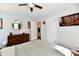 Bright bedroom featuring a ceiling fan, round mirror, and a dresser against light gray walls at 6187 Crittenden Ave, Indianapolis, IN 46220