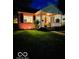 Charming brick bungalow with a cozy, covered front porch illuminated at night at 6187 Crittenden Ave, Indianapolis, IN 46220