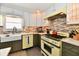 Charming kitchen with tiled backsplash, white upper cabinets and unique retro yellow range at 6187 Crittenden Ave, Indianapolis, IN 46220