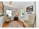 Cozy living room with wood floors, comfortable chairs, and natural light from multiple windows at 6187 Crittenden Ave, Indianapolis, IN 46220