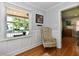 Bright living room with hardwood floors, white wainscoting, and a large window offering a view of the outside at 6187 Crittenden Ave, Indianapolis, IN 46220