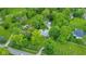 Aerial view of a home with mature trees, a driveway, and detached garages at 6430 E Southport Rd, Indianapolis, IN 46237