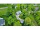 Aerial view showcasing a home with mature trees, a driveway, and detached garages at 6430 E Southport Rd, Indianapolis, IN 46237