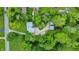 Aerial view of a home nestled among lush trees, featuring a driveway and detached garages at 6430 E Southport Rd, Indianapolis, IN 46237