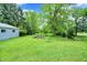 Spacious backyard with mature trees and a small shed, perfect for outdoor activities and relaxation at 6430 E Southport Rd, Indianapolis, IN 46237