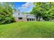 Expansive backyard showcases lush greenery, mature trees, and the home's exterior at 6430 E Southport Rd, Indianapolis, IN 46237
