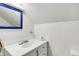 A charming bathroom featuring a blue-framed mirror and a well-lit vanity sink at 6430 E Southport Rd, Indianapolis, IN 46237