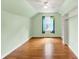 Bedroom with wood floor, green walls, window and closet space at 6430 E Southport Rd, Indianapolis, IN 46237