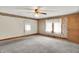 Bright bedroom featuring neutral carpet, ceiling fan, and floral wallpaper accents at 6430 E Southport Rd, Indianapolis, IN 46237