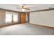 Bedroom with neutral carpet, trim accents, a ceiling fan, and view to the outside at 6430 E Southport Rd, Indianapolis, IN 46237