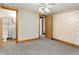 This bedroom features neutral carpeting, an ensuite bathroom and a ceiling fan at 6430 E Southport Rd, Indianapolis, IN 46237