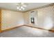 Bright bedroom features floral wallpaper, neutral carpet, and a window at 6430 E Southport Rd, Indianapolis, IN 46237