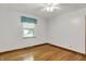 Bedroom with hardwood floors, white walls and a window with teal curtain at 6430 E Southport Rd, Indianapolis, IN 46237