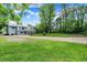 Two-story home with a large driveway, fenced yard, and mature trees offering privacy and curb appeal at 6430 E Southport Rd, Indianapolis, IN 46237