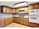 Kitchen with light wood cabinets, white countertops, and updated appliances at 6430 E Southport Rd, Indianapolis, IN 46237