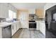 Bright kitchen featuring white cabinets, stainless steel appliances, and tile backsplash at 6430 E Southport Rd, Indianapolis, IN 46237