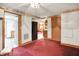 Inviting living room with red carpet, open access to other rooms, and neutral wall colors at 6430 E Southport Rd, Indianapolis, IN 46237