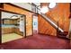 View of living room with wood paneled walls, stairs to the upper level and a doorway to the kitchen at 6430 E Southport Rd, Indianapolis, IN 46237