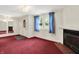 Bright living room with a fireplace, blue curtains, and red carpet flooring at 6430 E Southport Rd, Indianapolis, IN 46237
