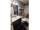 Well-lit bathroom featuring gray vanity, decorative shelving, and a shower-tub combo at 6637 Larkwood Ct, Indianapolis, IN 46241