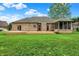A beautiful well-manicured backyard with brick home, screened porch, and deck at 7310 Monaghan Ln, Indianapolis, IN 46217