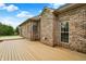 An exterior shot of the backyard deck with brick home and landscaped backyard with blue sky and fluffy white clouds at 7310 Monaghan Ln, Indianapolis, IN 46217