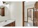 Comfortable bathroom with vanity, mirror, and warm lighting; view into bedroom at 7310 Monaghan Ln, Indianapolis, IN 46217