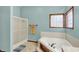 Bathroom features a bathtub, tile floors, blue walls, and a glass shower at 7310 Monaghan Ln, Indianapolis, IN 46217