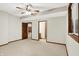 Spacious bedroom with three entryways, carpet flooring, and a ceiling fan at 7310 Monaghan Ln, Indianapolis, IN 46217