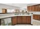 Kitchen area featuring custom wood cabinetry, white countertop and stainless steel appliances, with dining room in background at 7310 Monaghan Ln, Indianapolis, IN 46217