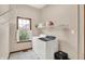 Well-lit laundry room with window, modern washer and dryer, and convenient shelving at 7310 Monaghan Ln, Indianapolis, IN 46217