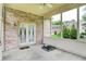 Enclosed brick patio with a ceiling fan, slider door, and views of the home's exterior at 7310 Monaghan Ln, Indianapolis, IN 46217