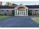 Clubhouse exterior with brick facade, arched windows, white columns, and a paved driveway at 7601 Newport Bay Dr # 203, Indianapolis, IN 46240