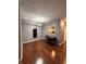 Bright dining room with hardwood floors, minimalist table set, and a pass-through window to kitchen at 7601 Newport Bay Dr # 203, Indianapolis, IN 46240