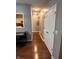 Hallway featuring a view into the kitchen and closet doors, along with hardwood floors at 7601 Newport Bay Dr # 203, Indianapolis, IN 46240
